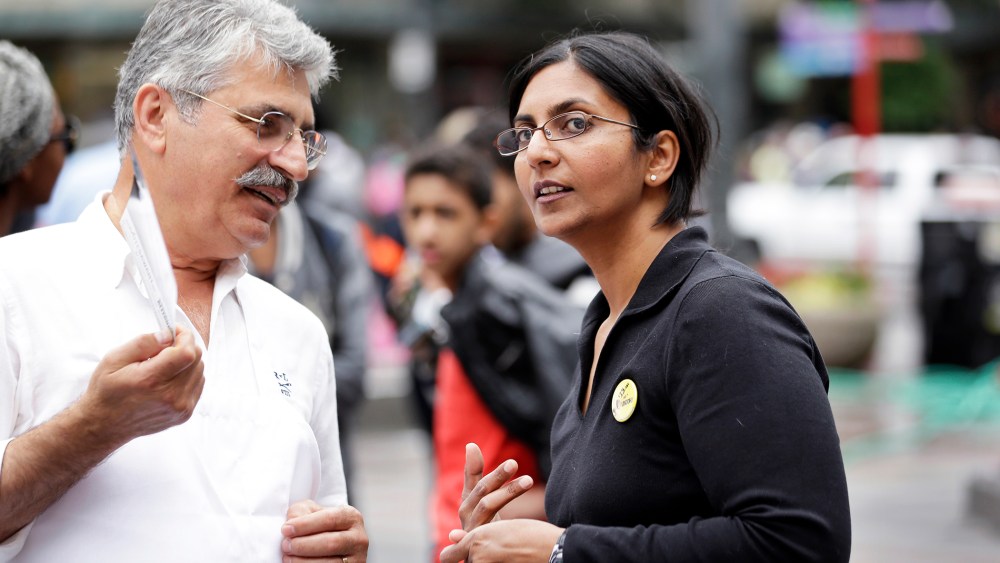 Seattle City Council candidate Kshama Sawant, right, speaks with a restaurant worker during a demonstration in Seattle, Aug. 1, 2013.