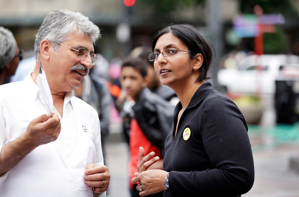 Seattle City Council candidate Kshama Sawant, right, speaks with a restaurant worker during a demonstration in Seattle, Aug. 1, 2013.