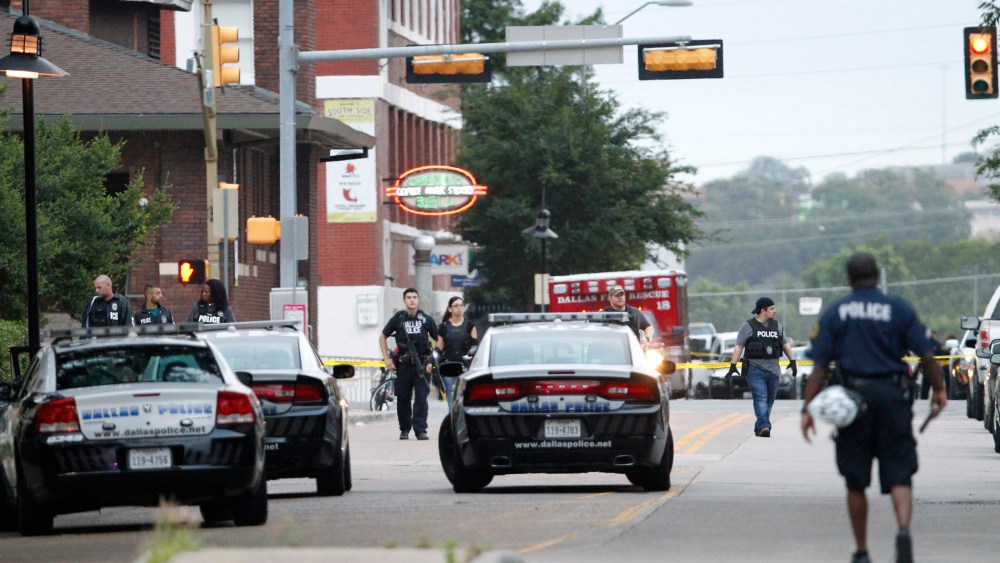 Dallas police officers walk down Belleview Street one block away from police headquarters searching the area on June 13, 2015, in Dallas, Texas. (Photo by Tony Gutierrez/AP)