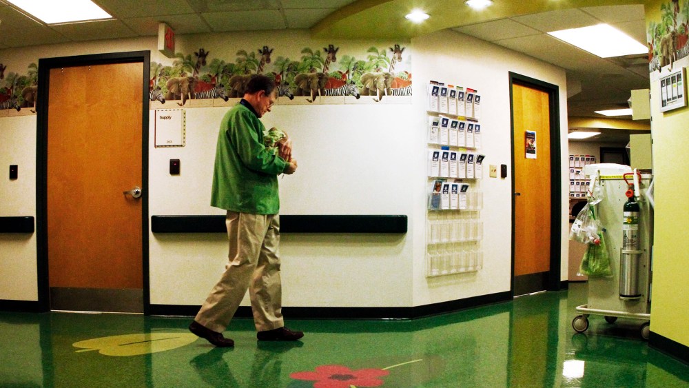 A volunteer cuddler walks the hallway with a baby at East Tennessee Children's Hospital in Knoxville. The baby is one of many infants born dependent on drugs being treated at the facility, March 29, 2013.