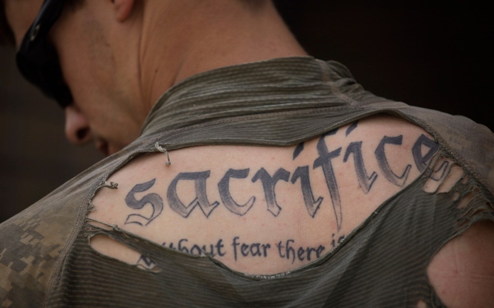 FILE - In this May 8, 2010 file photo, a tattoo on the back of U.S. Army Sgt. James Wilkes of Rochester, N.Y., is seen through his torn shirt after a foot patrol with 1st Platoon, Charlie Company, 2nd Battalion, 1st Infantry Regiment, of the 5th Styker...