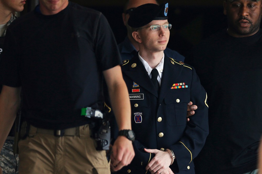 Chelsea Manning is escorted out of a courthouse in Fort Meade, Md., July 30, 2013.