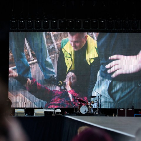 Foo Fighters' Dave Grohl is pictured on a big screen talking in a microphone after falling from the stage, during the band's concert at Nya Ullevi in Gothenburg, Sweden, Friday, June 12, 2015. (Photo by Erik Abel/TT/AP)