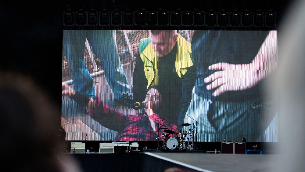 Foo Fighters' Dave Grohl is pictured on a big screen talking in a microphone after falling from the stage, during the band's concert at Nya Ullevi in Gothenburg, Sweden, Friday, June 12, 2015. (Photo by Erik Abel/TT/AP)