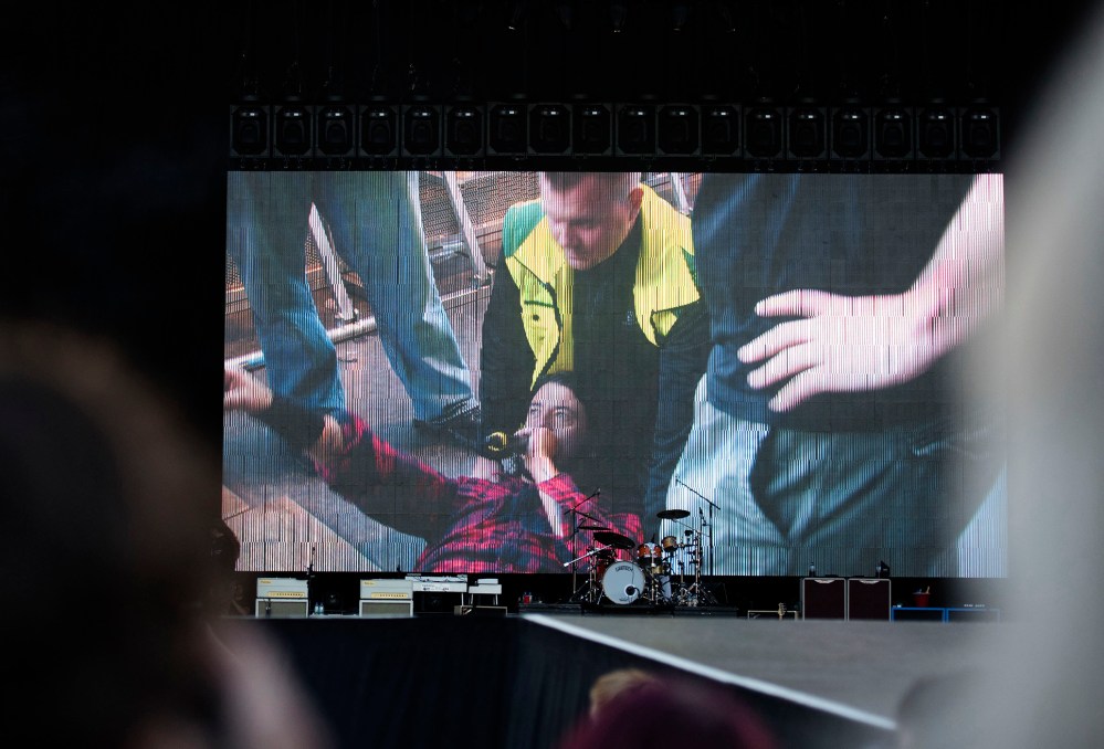 Foo Fighters' Dave Grohl is pictured on a big screen talking in a microphone after falling from the stage, during the band's concert at Nya Ullevi in Gothenburg, Sweden, Friday, June 12, 2015. (Photo by Erik Abel/TT/AP)