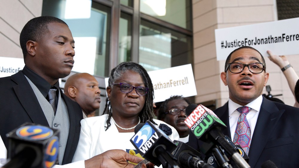 Willie and Georgia Ferrell listen as their attorney, Christopher Chestnut, talks with reporters about the mistrial in the case of Charlotte policeman Wes Kerrick accused of killing their brother and son, Jonathan, Aug. 21, 2015. (Photo by Bob Leverone/AP)