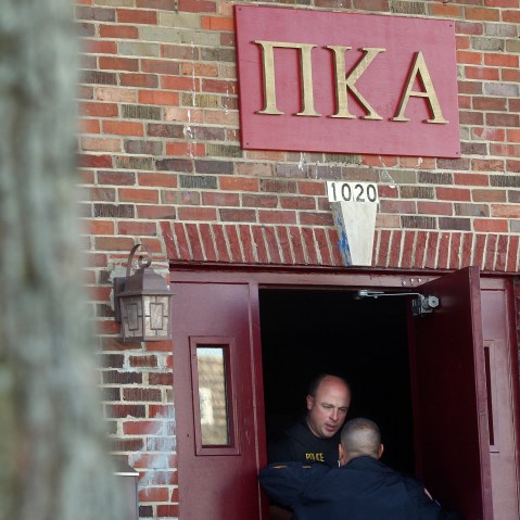 DeKalb and Northern Illinois University police speak in the doorway of the Pi Kappa Alpha house in DeKalb, Ill. where police were investigating the death of NIU freshman David Bogenberger, Nov. 2, 2012. (Photo by Kyle Bursaw/Daily Chronicle/AP)