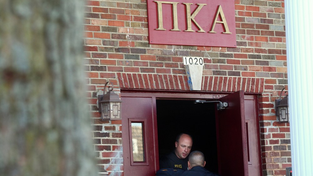 DeKalb and Northern Illinois University police speak in the doorway of the Pi Kappa Alpha house in DeKalb, Ill. where police were investigating the death of NIU freshman David Bogenberger, Nov. 2, 2012. (Photo by Kyle Bursaw/Daily Chronicle/AP)