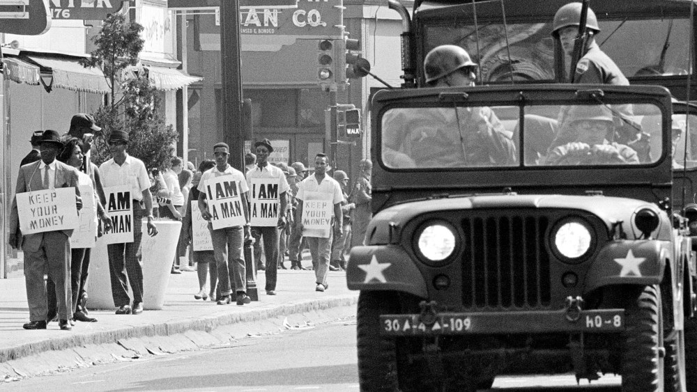 File Photo: Tennessee National Guard troopers in jeeps and trucks escort a protest march by striking Memphis sanitation workers through downtown Memphis Saturday afternoon March 30, 1968. (AP Photo, File)