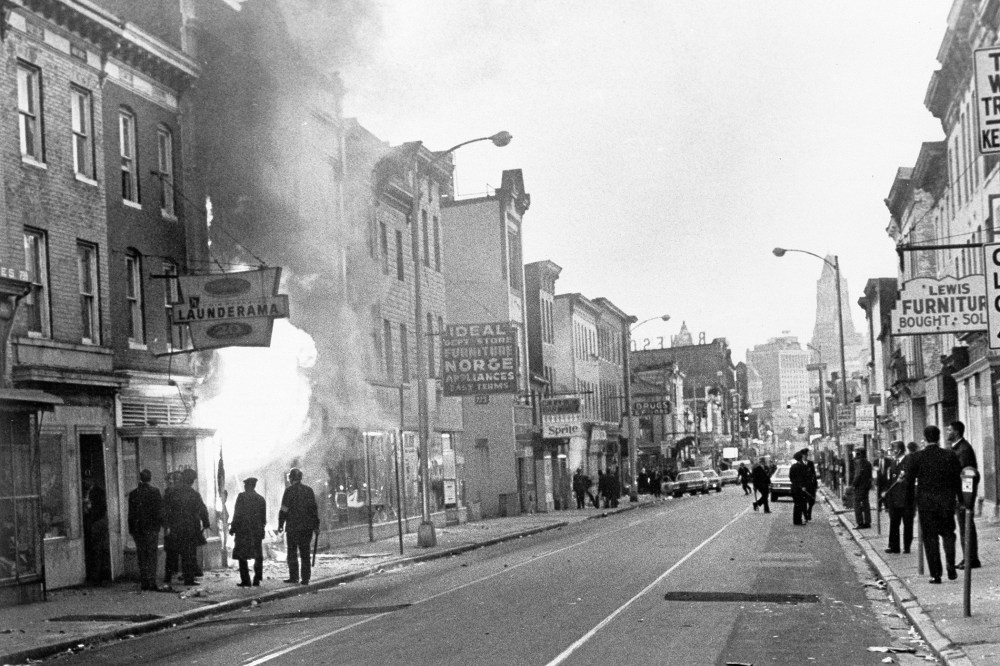 Fire shoots out from a Baltimore store on Gay Street as looting erupted in a five-block business section in Baltimore on April 6, 1968.
