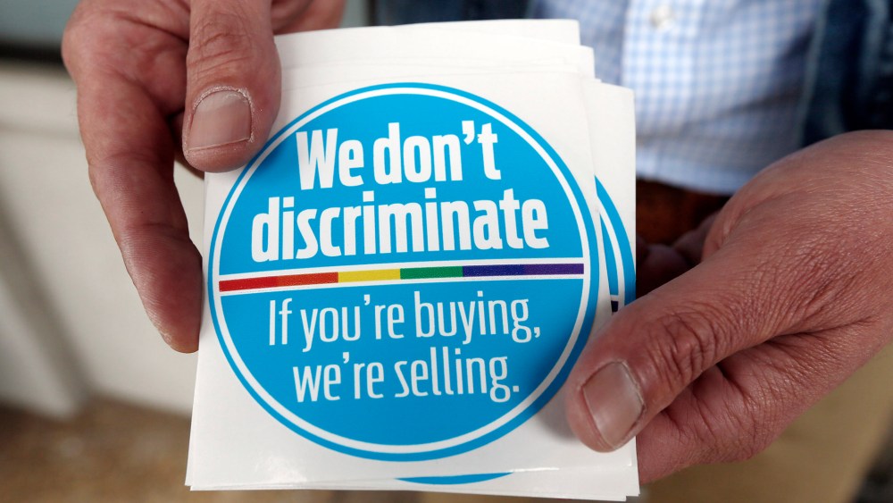 Eddie Outlaw, a Jackson hair salon owner, displays the stickers he and some other business owners display and have distributed to others in a show of support for gay and lesbian customers, on April 22, 2014, outside his business in Jackson, Miss.