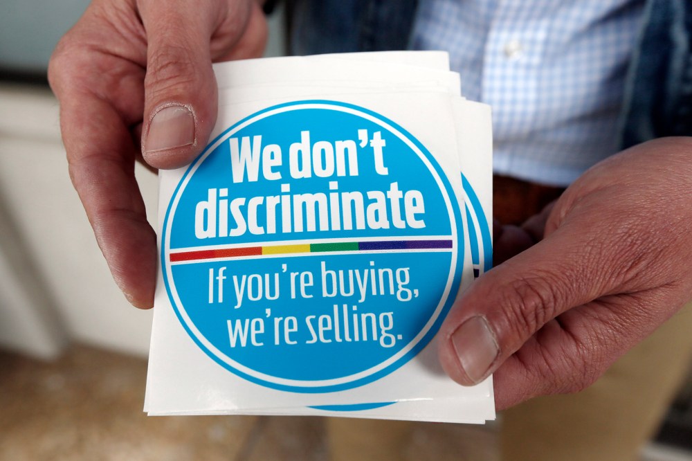 Eddie Outlaw, a Jackson hair salon owner, displays the stickers he and some other business owners display and have distributed to others in a show of support for gay and lesbian customers, on April 22, 2014, outside his business in Jackson, Miss.