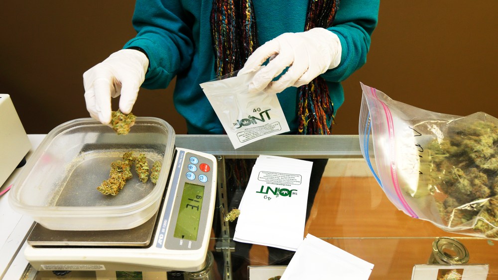 Monique Rydberg weighs and packages medical marijuana in Seattle, Oct. 16, 2013.