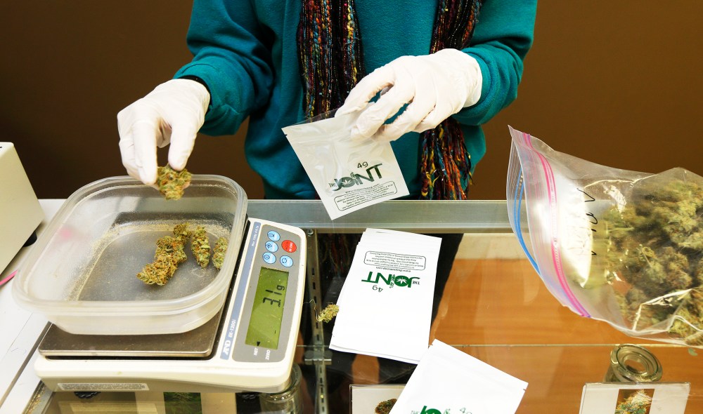 Monique Rydberg weighs and packages medical marijuana in Seattle, Oct. 16, 2013.