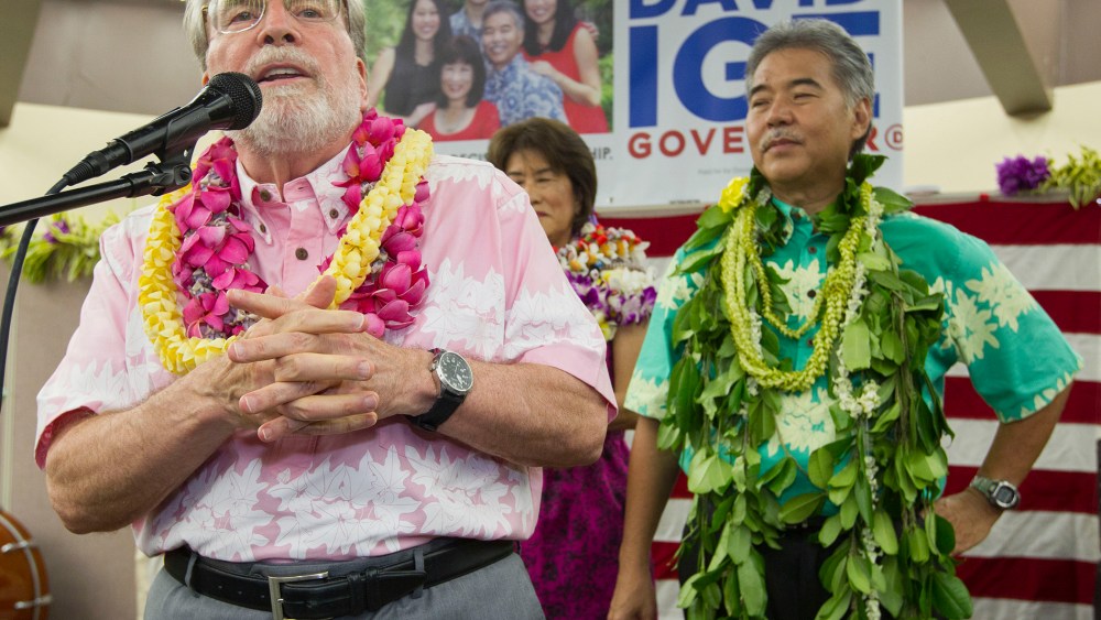 Hawaii Governor Neil Abercrombie, left, addresses the supporters of Hawaii State Sen. David Ige as Ige, right, looks, Aug. 9, 2014, in Honolulu, Hawaii.