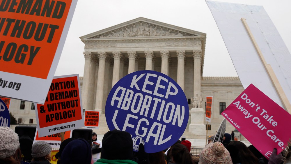 Pro-choice signs are seen during the March for Life 2016, in front of the U.S. Supreme Court, Jan. 22, 2016. (Photo by Alex Brandon/AP)