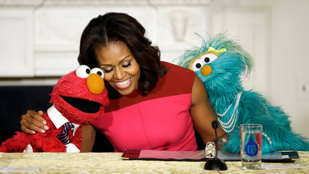 First lady Michelle Obama with Sesame Street characters Elmo and Rosita, as they help promote fresh fruit and vegetable consumption to kids at the White House, Wednesday, Oct. 30, 2013.