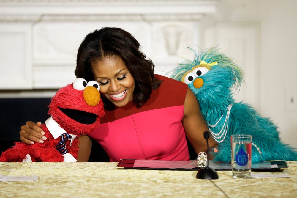 First lady Michelle Obama with Sesame Street characters Elmo and Rosita, as they help promote fresh fruit and vegetable consumption to kids at the White House, Wednesday, Oct. 30, 2013.