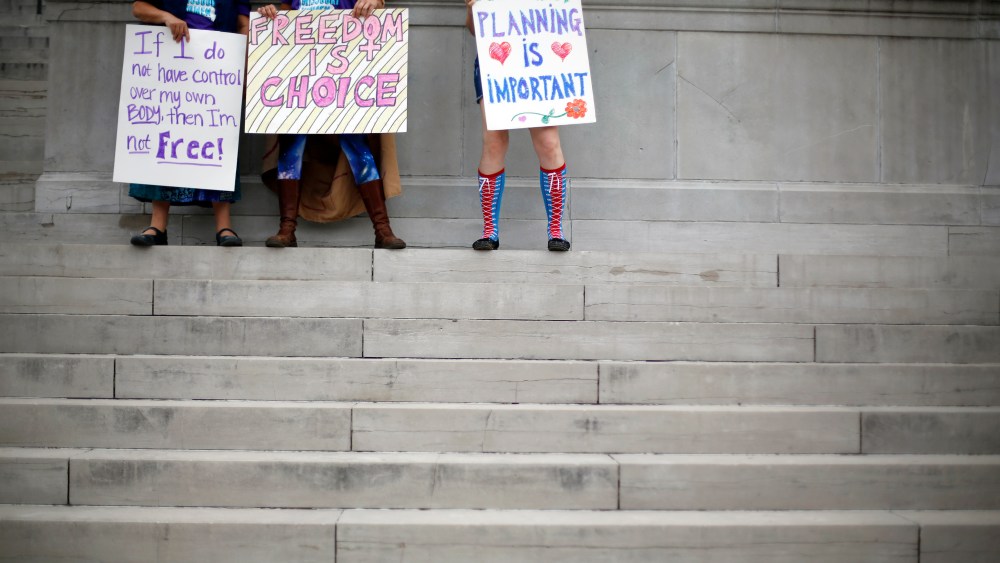 Abortion rights activists hold signs as they stand on the steps of the Missouri Capitol on Sept. 10, 2014, in Jefferson City, Mo. (Jeff Roberson/AP)