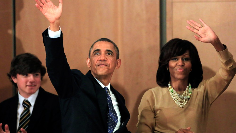 US President Barack Obama, left, waves while walking with First Lady Michelle Obama after he delivered a keynote address ahead of the G-8 summit at Waterfront Hall in Belfast, Northern Ireland on Monday, June 17, 2013. (AP Photo/Peter Morrison)