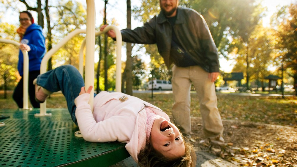 A family plays at a playground at Overton Park in Memphis, Tenn.