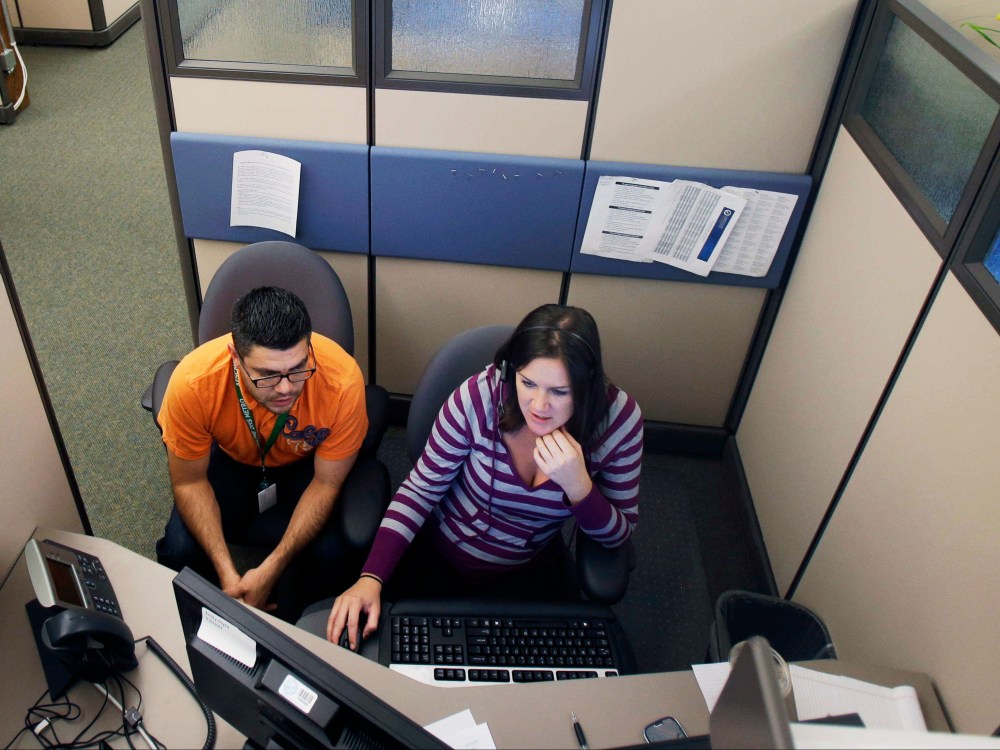 MNsure insurance exchange representatives Carlos Villanueva, left, and Emily Joyce prepare for the Oct. 1 open enrollment debut at the center in St. Paul, Minnesota.