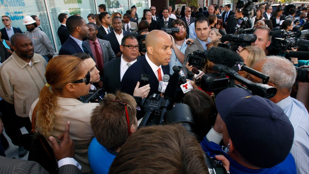 Democratic Newark Mayor and senate candidate Cory Booker, center, is surrounded by media as he answers questions in Newark, N.J. on Wednesday, Sept. 25, 2013, after a ribbon-cutting ceremony for Newark charter schools.