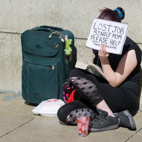 A woman in Chicago holding a sign that says: "Lost Job. Single Mom. Please Help." (Peer Grimm/picture-alliance/dpa/AP Images)