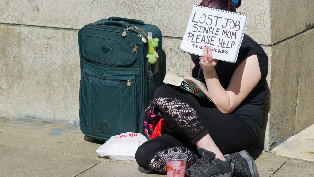 A woman in Chicago holding a sign that says: "Lost Job. Single Mom. Please Help." (Peer Grimm/picture-alliance/dpa/AP Images)