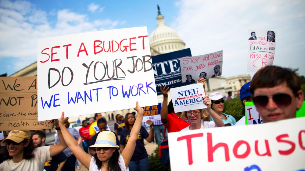 Protestors hold signs during a during an event with the Democratic Progressive Caucus and furloughed federal employees on Capitol Hill in Washington, Friday, Oct. 4, 2013.