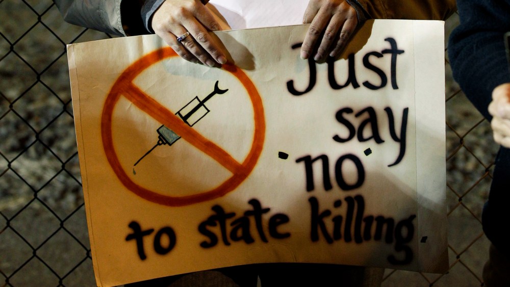 A woman holds a sign outside the Washington State Penitentiary, in Walla Walla, Wash, Sept. 9, 2010.