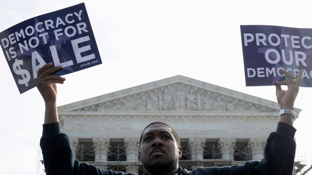 A man takes part in a demonstration outside the Supreme Court in Washington as the court heard arguments on campaign finance, Oct. 8, 2013.
