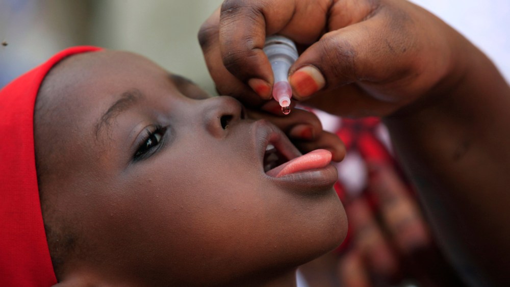 A health official administers a polio vaccine to a child in Kawo Kano, Nigeria, April 13, 2014. (Photo by Sunday Alamba/AP)