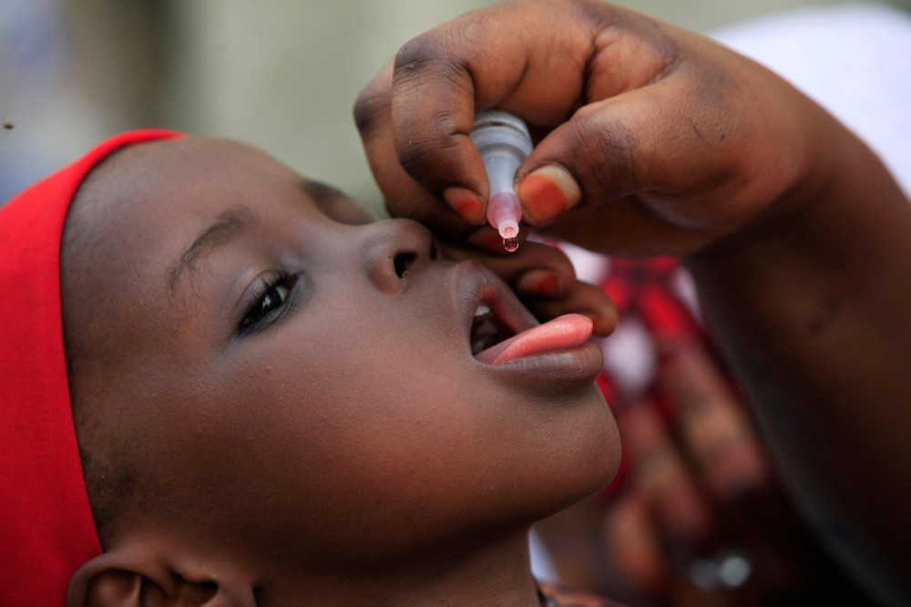A health official administers a polio vaccine to a child in Kawo Kano, Nigeria, April 13, 2014. (Photo by Sunday Alamba/AP)