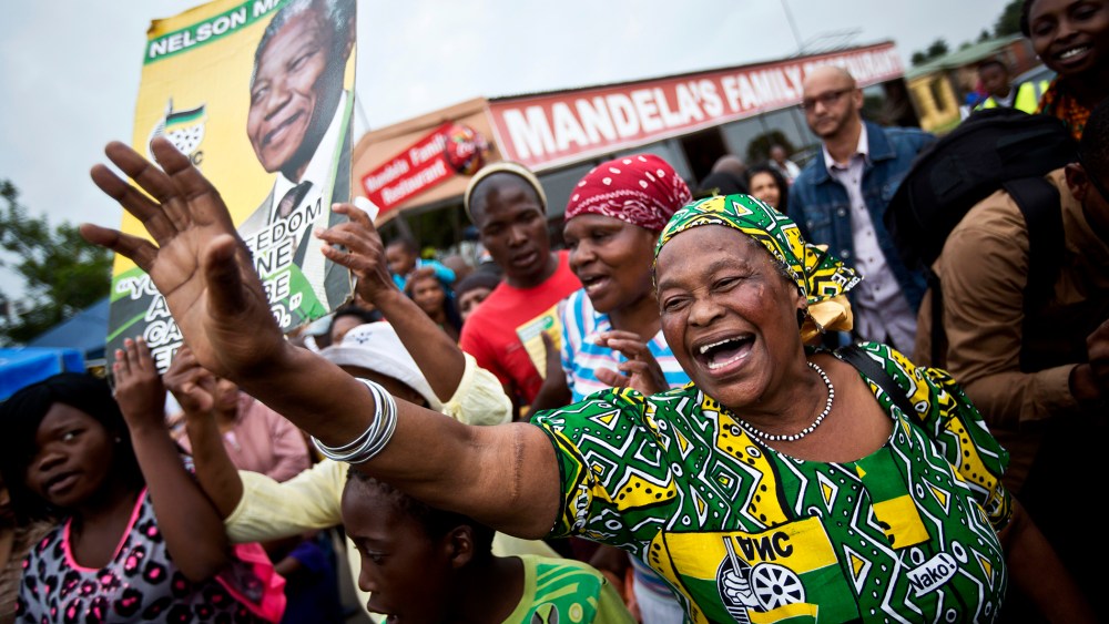 Mourners sing and dance to celebrate the life of Nelson Mandela, in the street outside his old house in Soweto, Johannesburg, South Africa on Dec. 6, 2013.