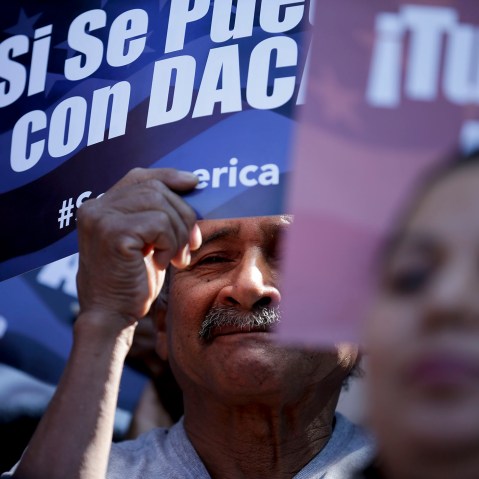 A man stands among signs during a rally in support of President Barack Obama's plan to protect more than 4 million people living illegally in the U.S. from deportation on Feb. 17, 2015, in San Diego. (Photo by Gregory Bull/AP)