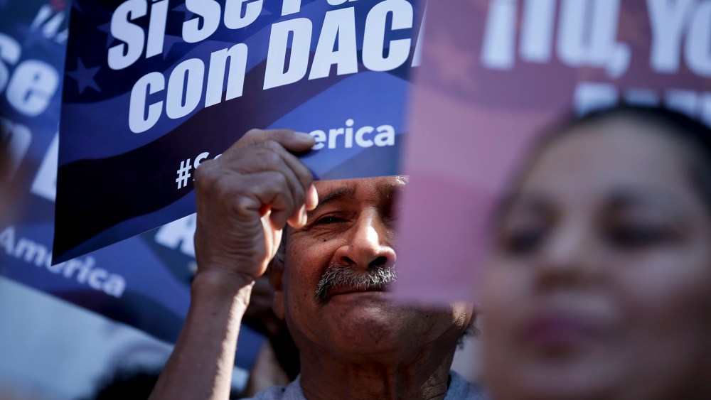 A man stands among signs during a rally in support of President Barack Obama's plan to protect more than 4 million people living illegally in the U.S. from deportation on Feb. 17, 2015, in San Diego. (Photo by Gregory Bull/AP)