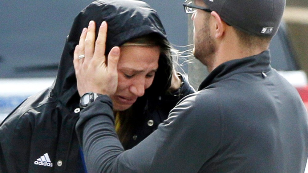 An unidentified Boston Marathon runner is comforted as she cries in the aftermath of two blasts which exploded near the finish line of the Boston Marathon in Boston. (Photo by Elise Amendola/AP Photo)