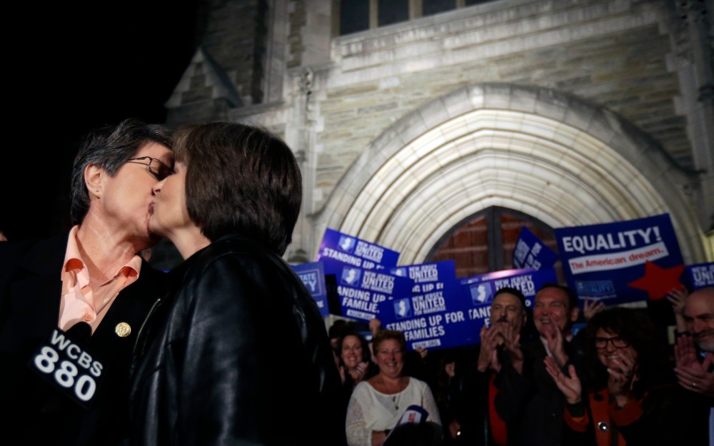 Cindy Meneghin, left, kisses her partner Maureen Kilian, both from Butler, N.J., during a news conference at Garden State Equality in Montclair, N.J.