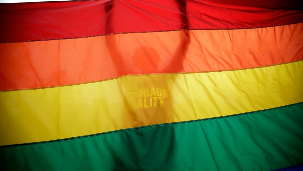 A gay marriage supporter holds up a flag during a rally for gay marriage, on June 26, 2013, on Independence Mall in Philadelphia.