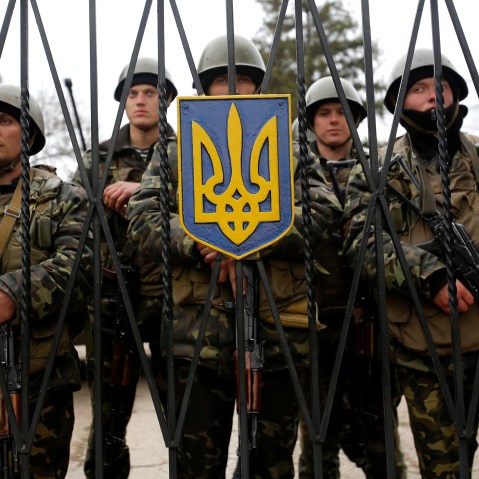 Ukrainian soldiers guard a gate of an infantry base that was surrounded by hundreds of unidentified soldiers, March 2, 2014, in Privolnoye, Ukraine.