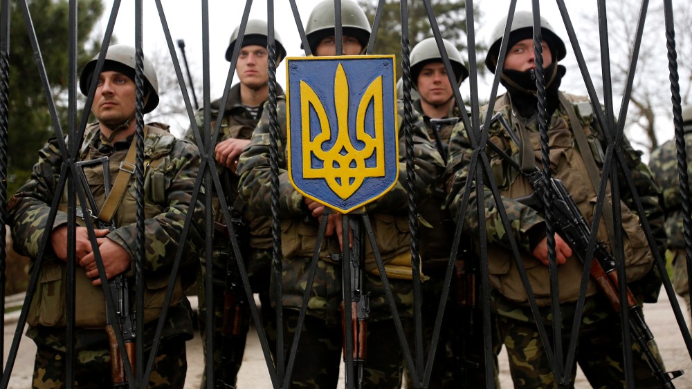 Ukrainian soldiers guard a gate of an infantry base that was surrounded by hundreds of unidentified soldiers, March 2, 2014, in Privolnoye, Ukraine.