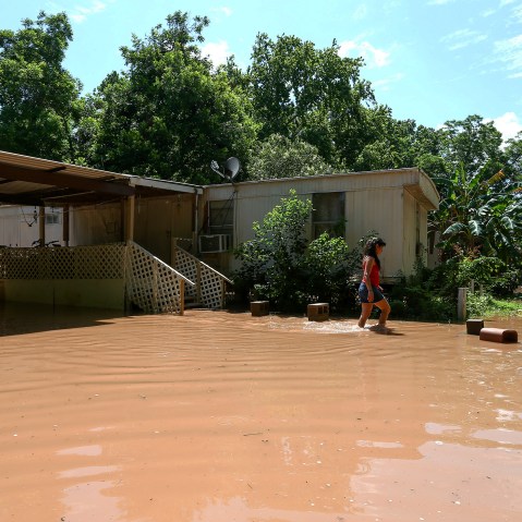 Irene Martinez, who lives near the Brazos River, leaves her flooded home, May 29, 2016, in Richmond, Texas. (Photo by Jon Shapley/Houston Chronicle/AP)