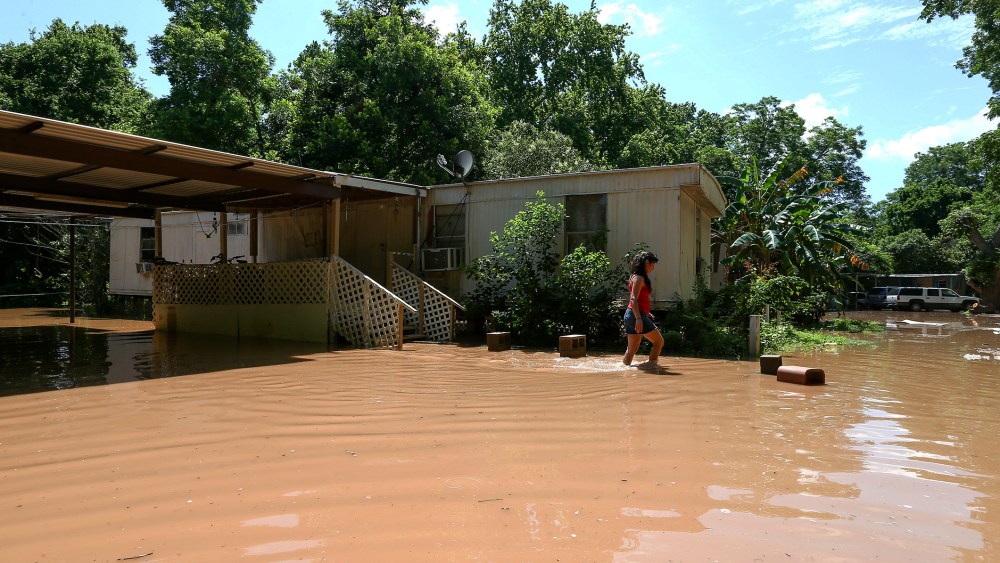 Irene Martinez, who lives near the Brazos River, leaves her flooded home, May 29, 2016, in Richmond, Texas. (Photo by Jon Shapley/Houston Chronicle/AP)