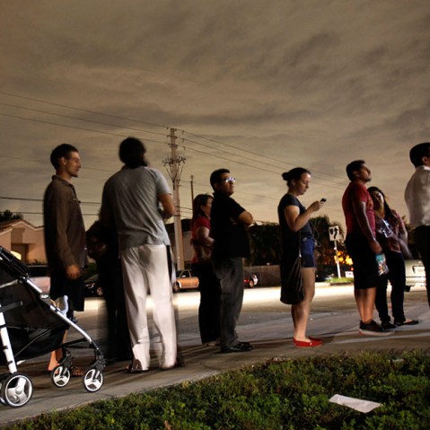 This Nov. 6, 2012 file photo shows voters lined up in the dark to beat the 7 p.m. deadline to cast their ballots at a polling station in Miami. (Photo by Wilfredo Lee/AP)