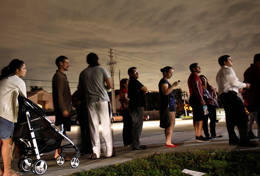 This Nov. 6, 2012 file photo shows voters lined up in the dark to beat the 7 p.m. deadline to cast their ballots at a polling station in Miami. (Photo by Wilfredo Lee/AP)