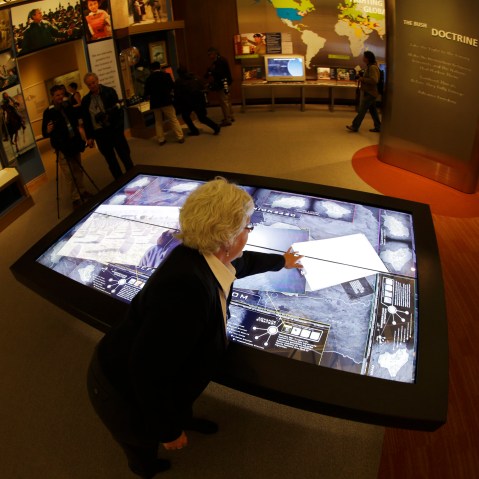 Docent Patricia Flynn demonstrates an interactive with information about conflicts in Afghanistan and Iraq during a tour of the George W. Bush Presidential Center Wednesday, April 24, 2013, in Dallas. More than 8,000 people are expected to attend the...