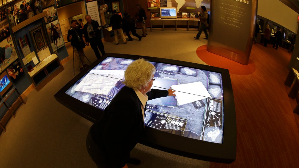 Docent Patricia Flynn demonstrates an interactive with information about conflicts in Afghanistan and Iraq during a tour of the George W. Bush Presidential Center Wednesday, April 24, 2013, in Dallas. More than 8,000 people are expected to attend the...