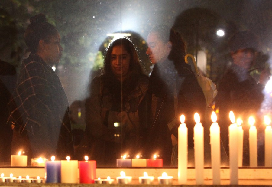 People are reflected in a window outside the French embassy in Seoul, South Korea, Nov. 14, 2015, for the victims killed in Friday's attacks in Paris. (Photo by Ahn Young-joon/AP)