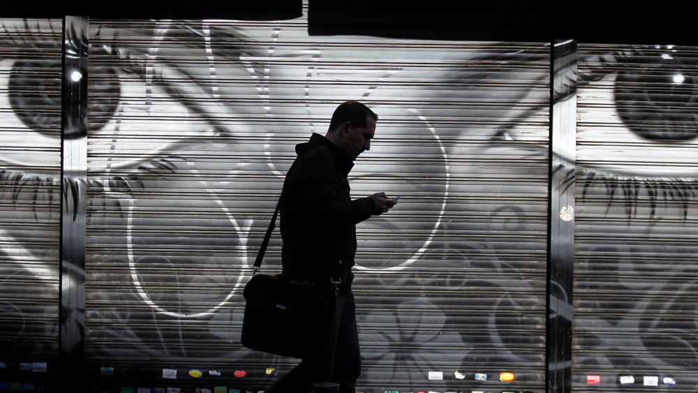 A man looks at his cell phone as he walks on the street in downtown Madrid, Oct. 31, 2013.
